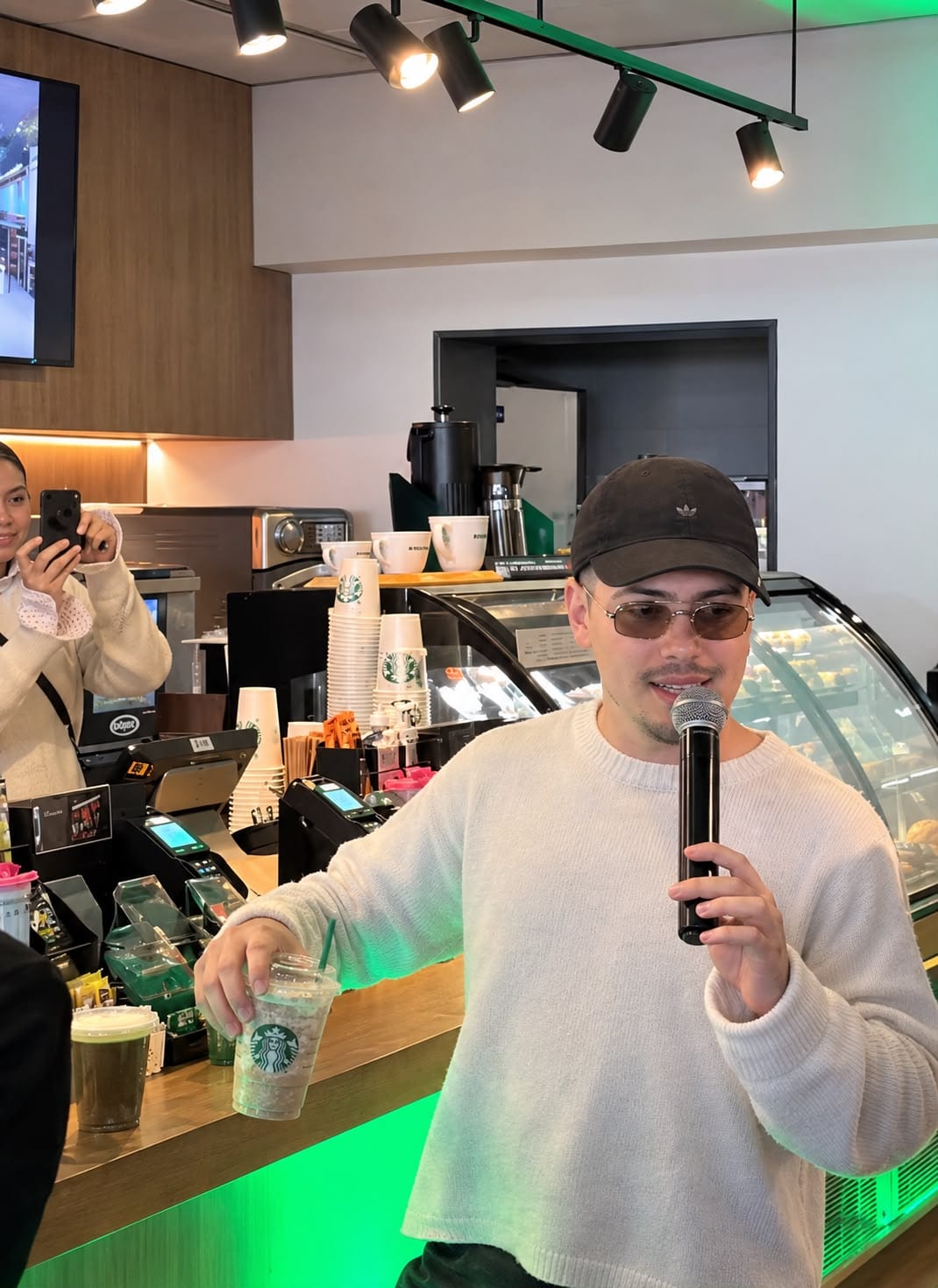 Integrante de Morat con micrófono frente a la barra de Starbucks